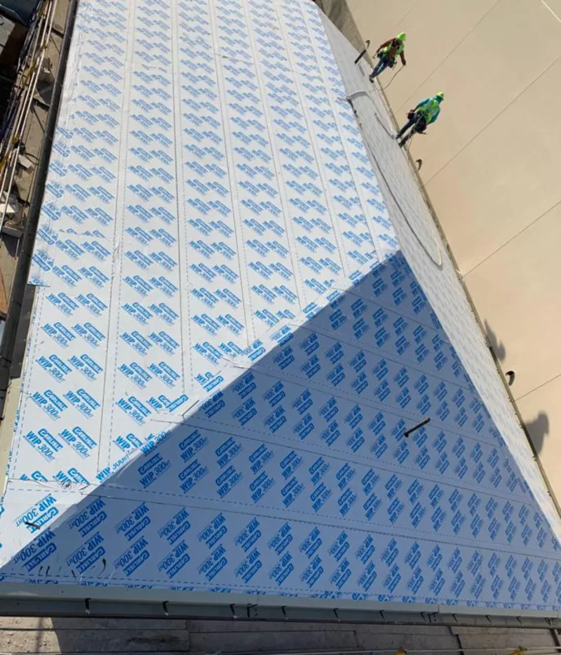 Professional roofers installing underlayment on a metal roof in Chippewa Falls